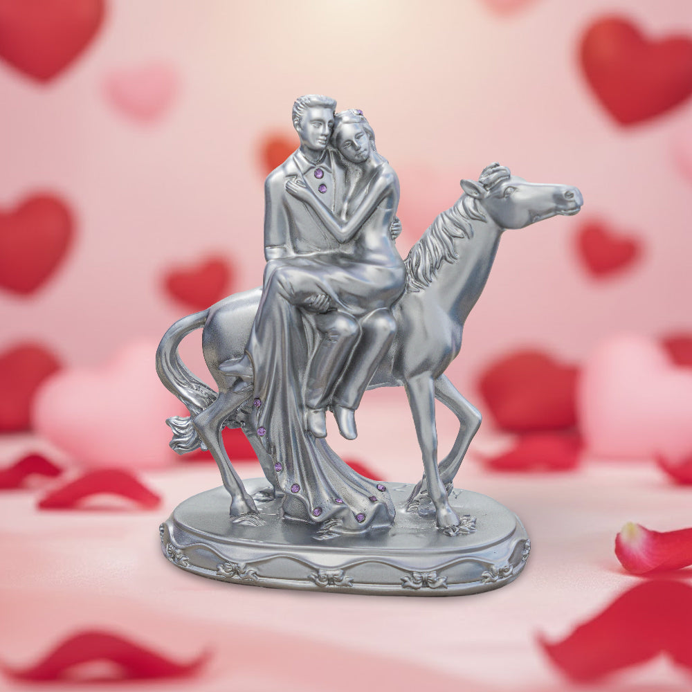 Statue of a couple on a horse with a heart-themed background